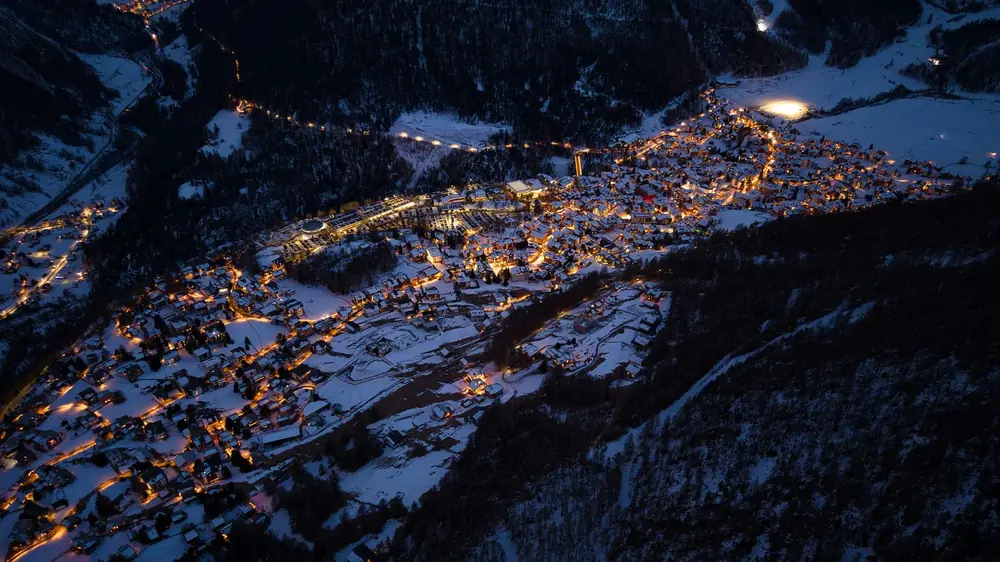 Station de ski enneigée vue du ciel, illuminée le soir